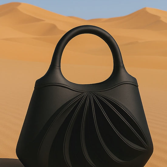 Video of Amaren, an elegant black leather handbag, handcrafted in France, in a sandstorm